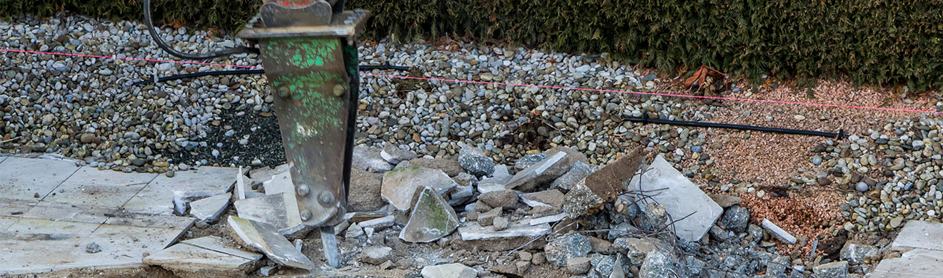 Bei Abbrucharbeiten in Wiesbaden reißt ein Meißel eines Baggers eine Wand aus Beton ein