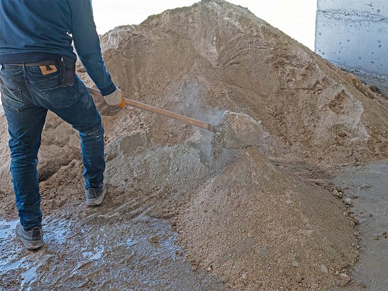 Bauarbeiter mischt Estrich Sand mit Zement auf Baustelle in Wiesbaden